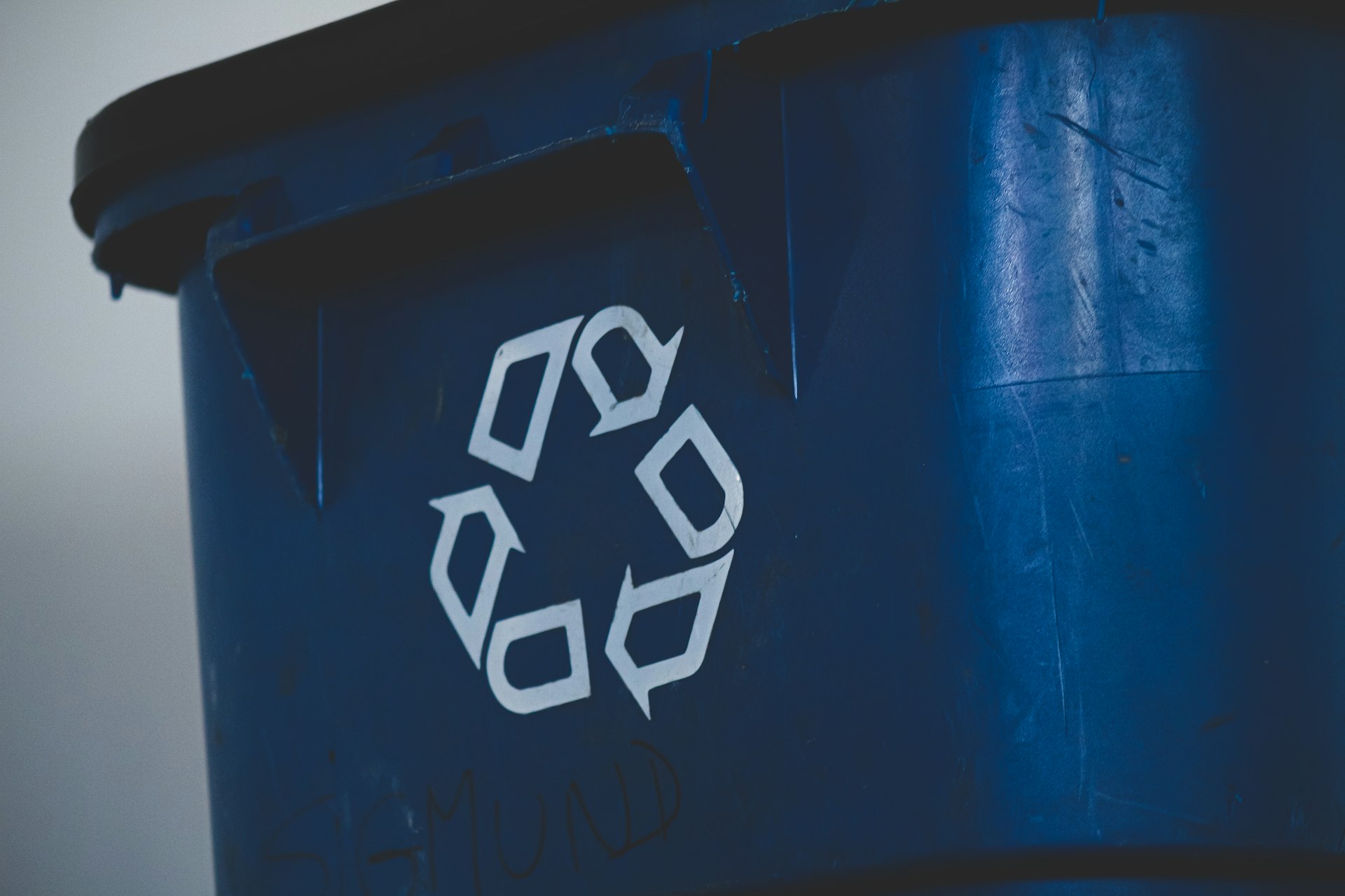 Blue recycling bin with white recycling symbol — responsible waste sorting